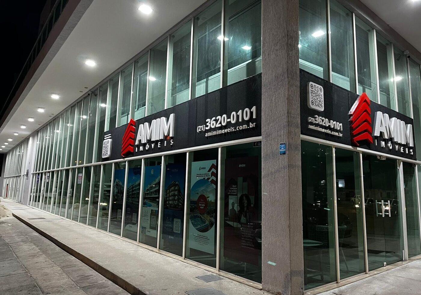 Fachada ACM Amim Imóveis iluminada à noite